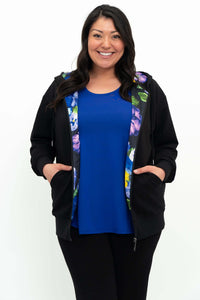 Close-up of woman in black hoody displaying the floral patterned lining
