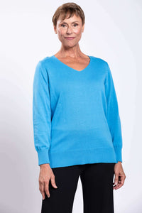 Front close-up of woman wearing blue V-neck cotton sweater with ribbed cuffs