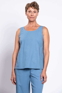 Woman wearing a sleeveless blue linen tank top with matching pants, close-up front view