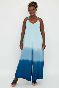 Model facing forward wearing a sleeveless blue ombre jumpsuit