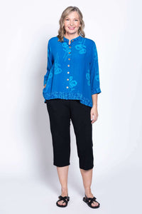Front full-length view of a woman modeling the blue floral cropped blouse and black pants