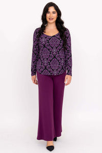 Full body front view of model in purple damask top paired with purple pants