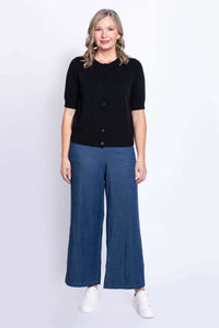 Front view of woman in black cotton cardigan and wide-leg blue pants