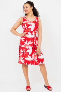 Front view of sleeveless red and white floral pleated dress on model