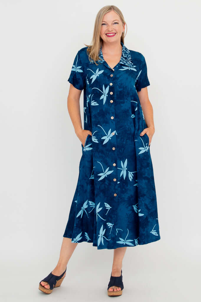 Front view of woman wearing a blue button-up dress with light blue dragonfly patterns