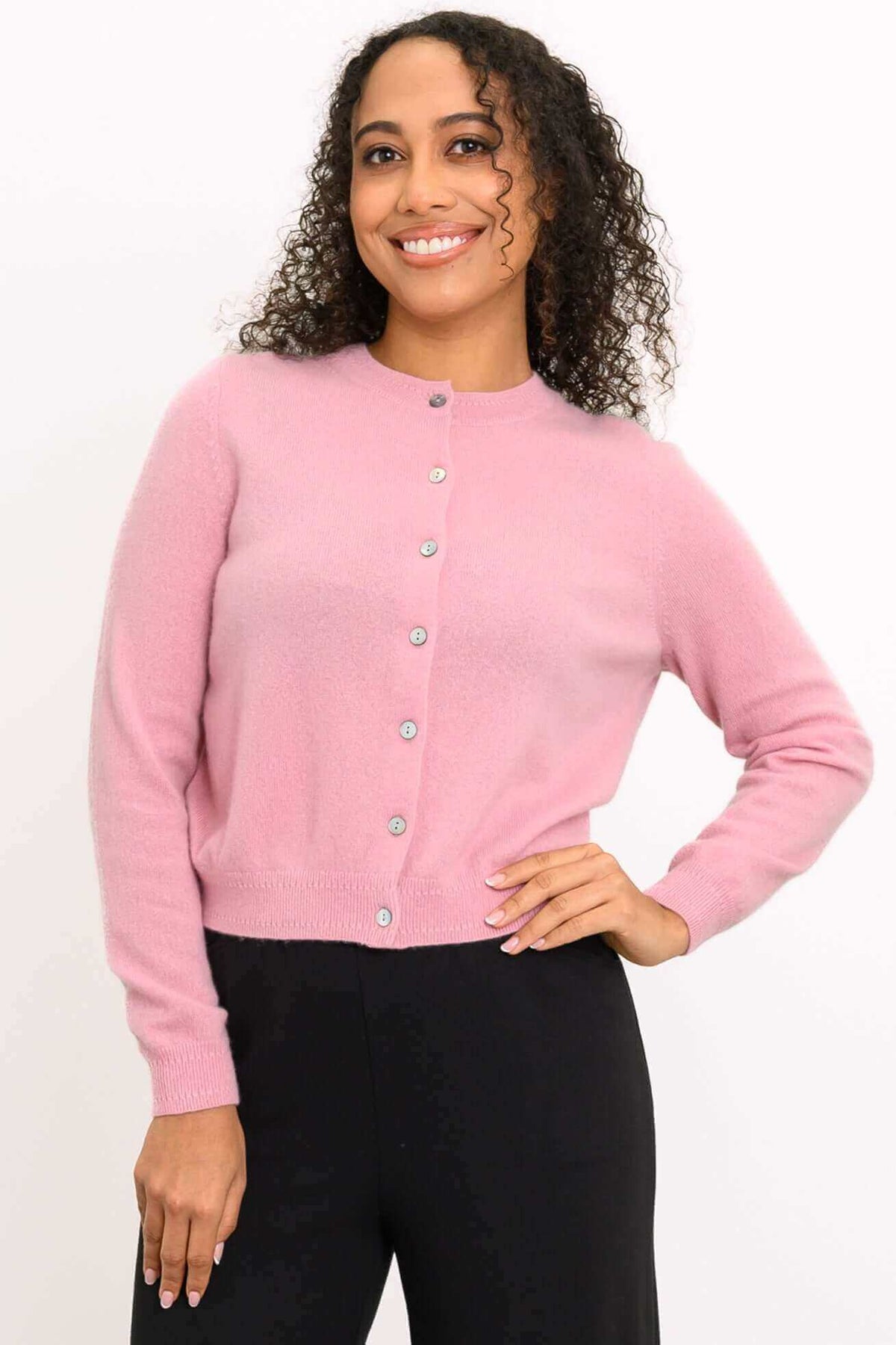 Front view of a woman wearing a pink cashmere cardigan with buttons