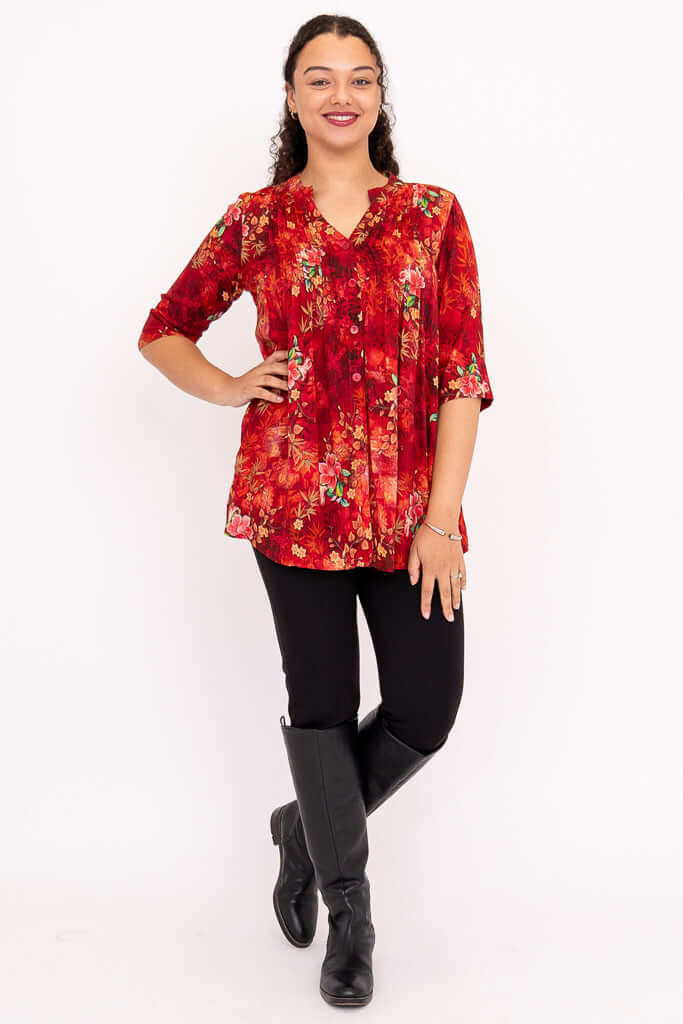 Model standing front-facing in Margate red floral blouse with hands on hips