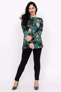 Woman posing in a green floral boat neck top with arms crossed, full body front