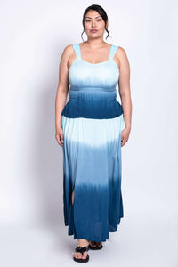 Full front stance of a model wearing a flowy blue ombre dress with slits at the hem