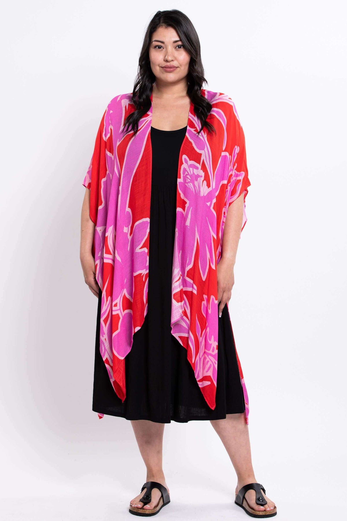 Front standing view of a woman in pink and red floral kimono wrap and black dress