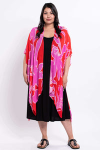 Front standing view of a woman in pink and red floral kimono wrap and black dress