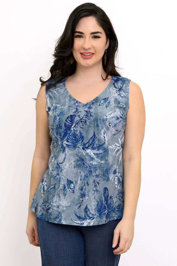 Front view of woman wearing a sleeveless blue botanical V-neck top