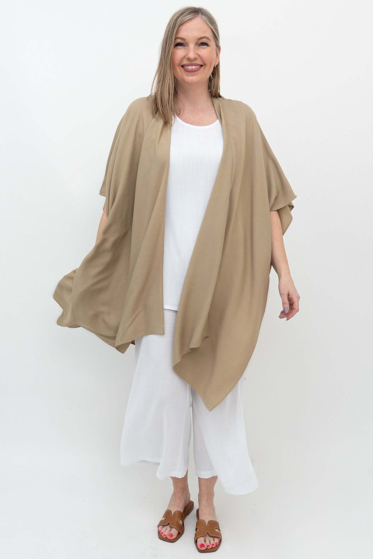 Front view of model wearing a sand-colored kimono wrap over white outfit