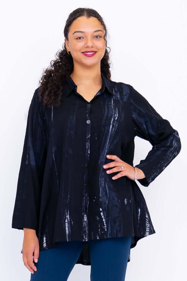 Front view of model wearing a black flowy button-up top with subtle blue patterns