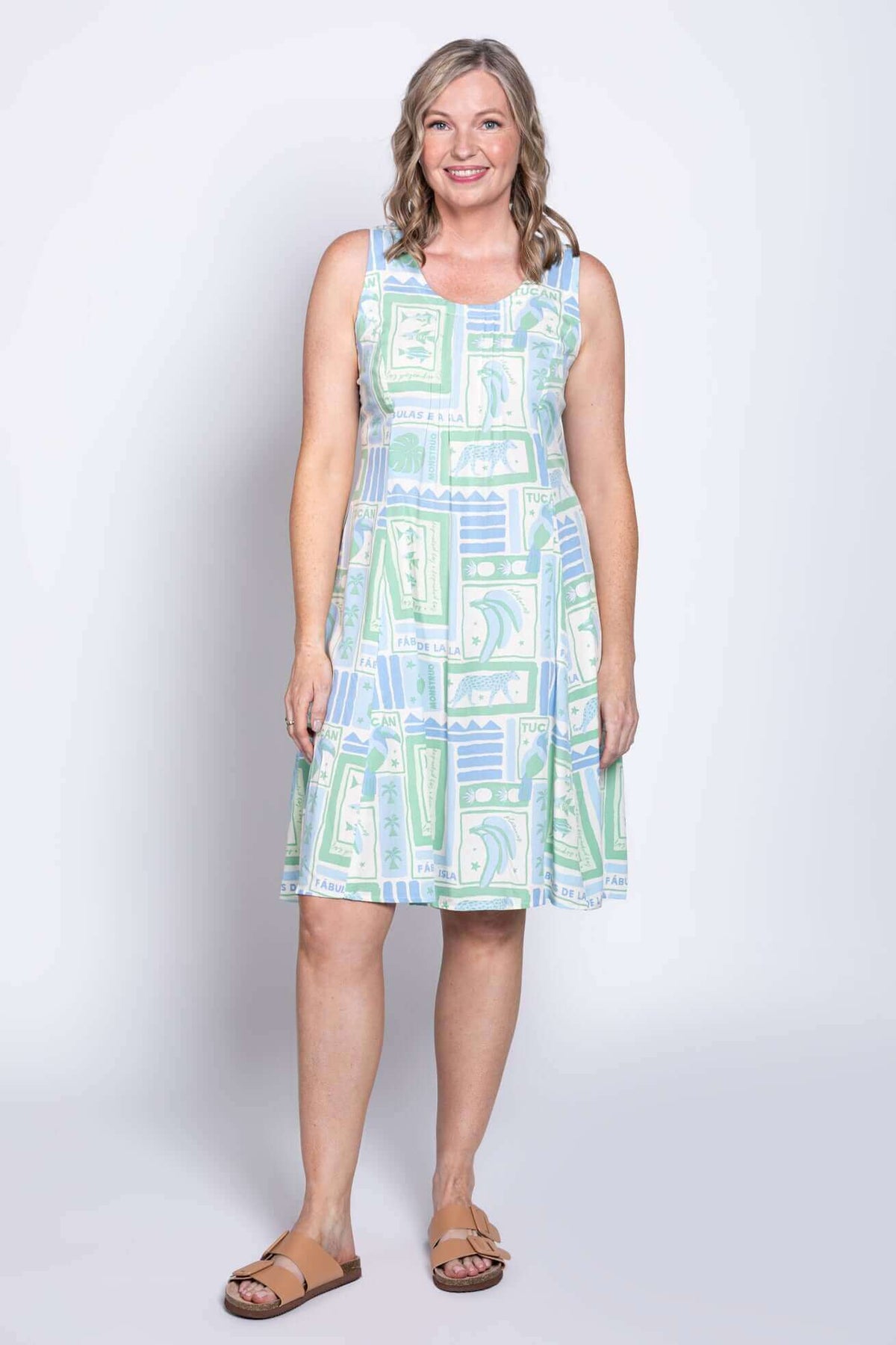 Front view of a woman wearing a sleeveless light green and blue patterned A-line dress