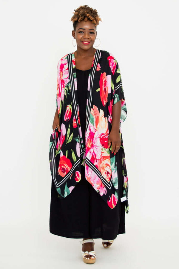 Front view of model wearing a black Darcy kimono wrap with vibrant floral print