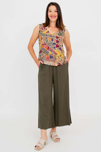 Front view of a woman in a sleeveless Havana bamboo linen tank and olive pants