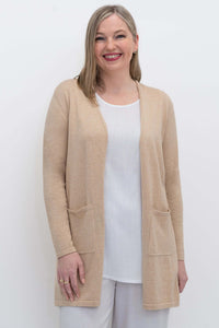 Front view of woman wearing a beige open cardigan sweater with patch pockets