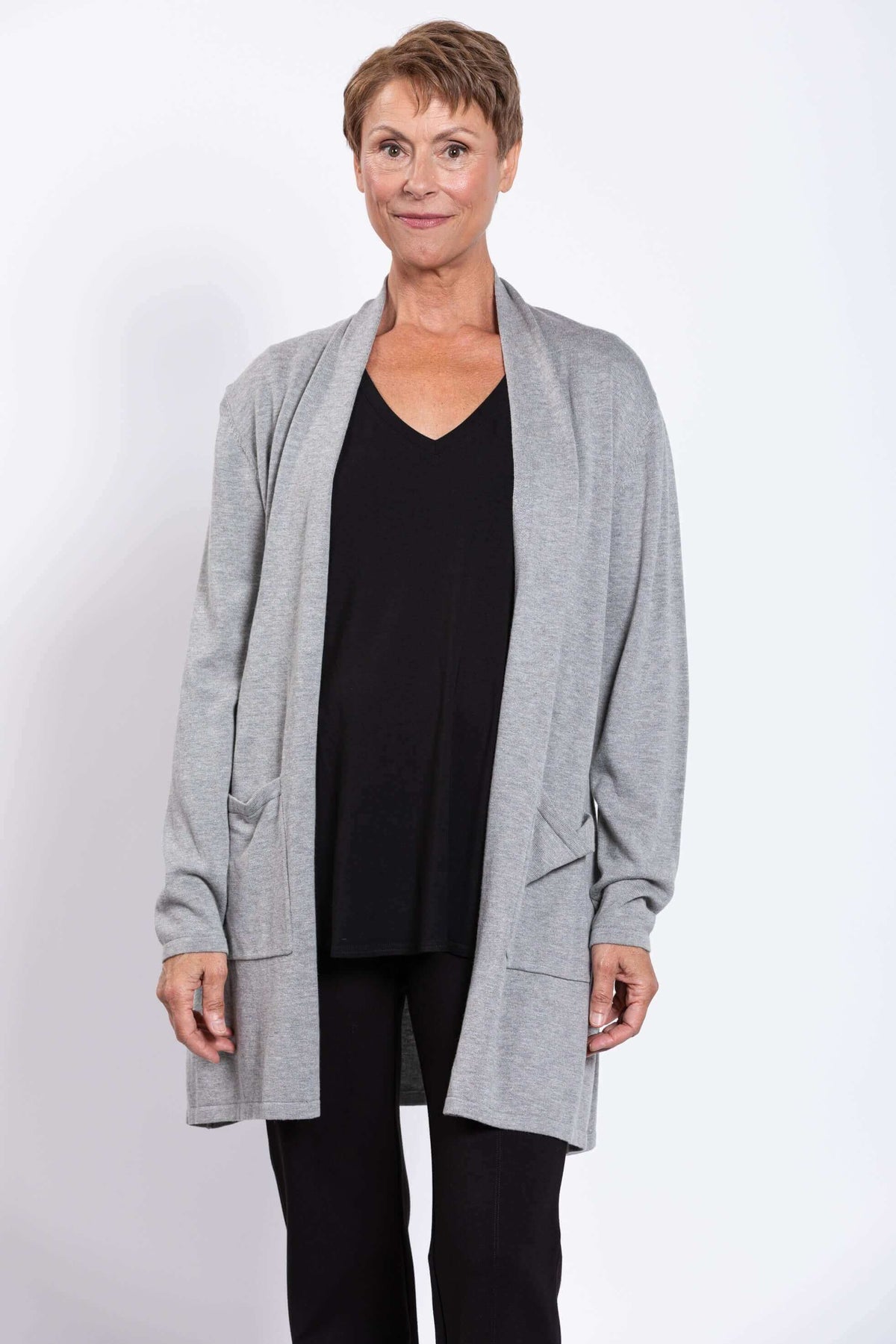 Front view of model wearing light grey open front cardigan with patch pockets