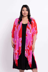 Front view of a woman wearing a pink and red floral kimono wrap over a black dress