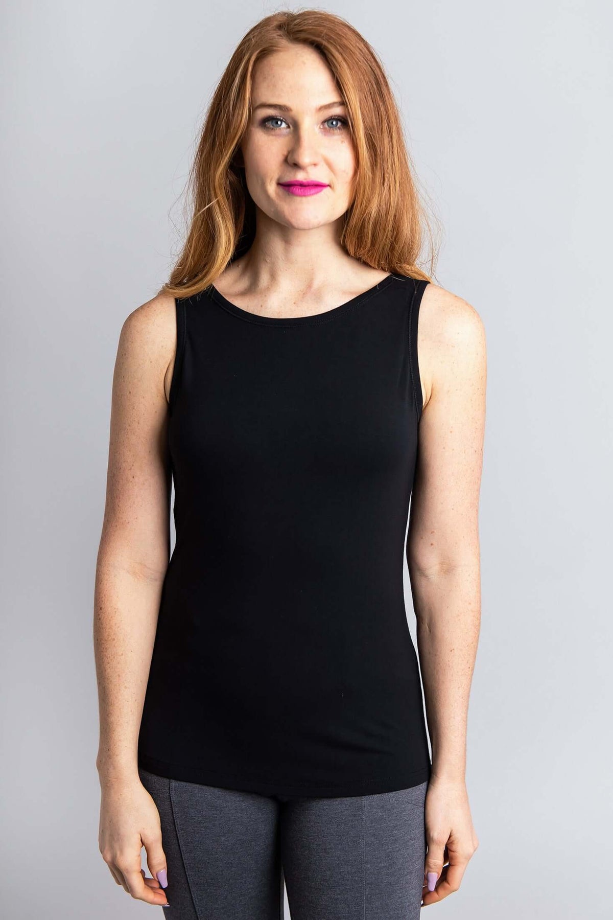 Front view of a woman in a black bamboo tank top with a scoop neckline