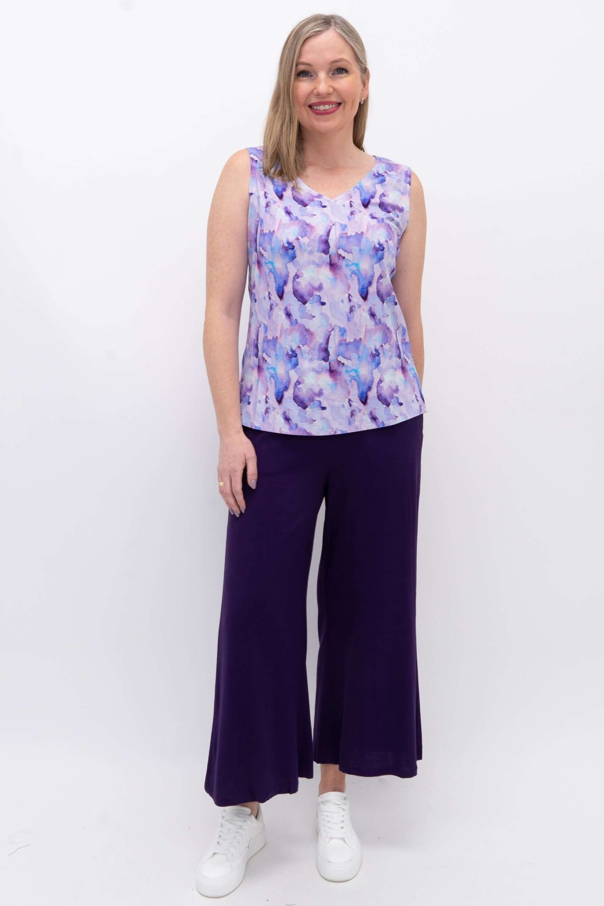Front view of model in purple watercolor V-neck tank and wide leg purple pants