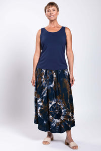Model standing front-facing in navy top and tie dye batik midi skirt, sandals shown