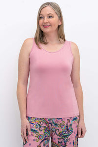 Woman wearing a pink bamboo tank top with colorful paisley pants, front view