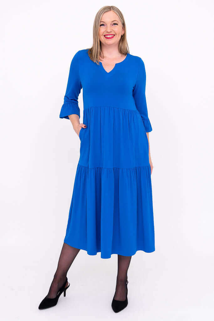 Model in a vibrant blue tiered midi dress with 3/4 ruffle sleeves, front view