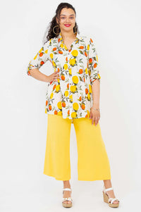 Model wearing a citrus print oversized tunic with yellow wide-leg pants, front view