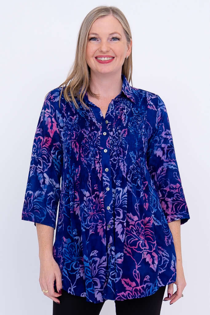 Woman wearing a blue and purple floral tunic with 3/4 sleeves, front view