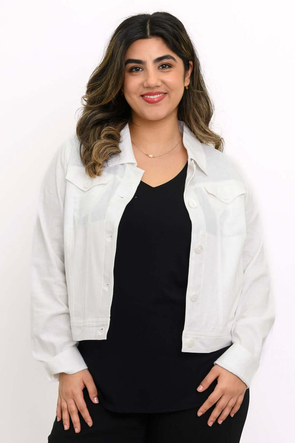 Front view of model wearing a white linen jean jacket over a black top
