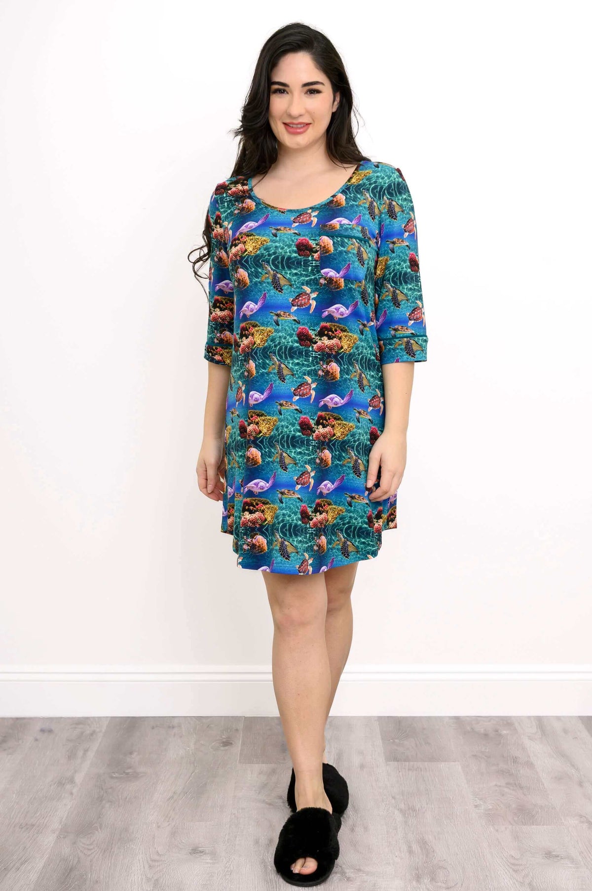Woman in a coral reef print bamboo sleepshirt standing and smiling, front view