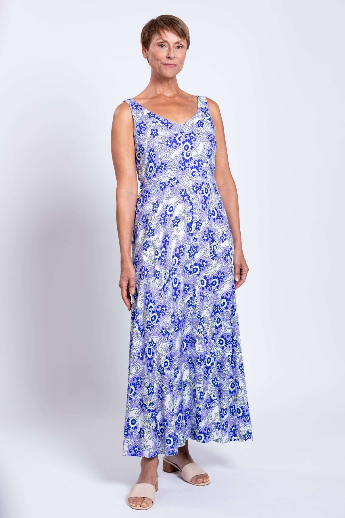 Front view of a woman wearing a blue paisley maxi dress with wide shoulder straps