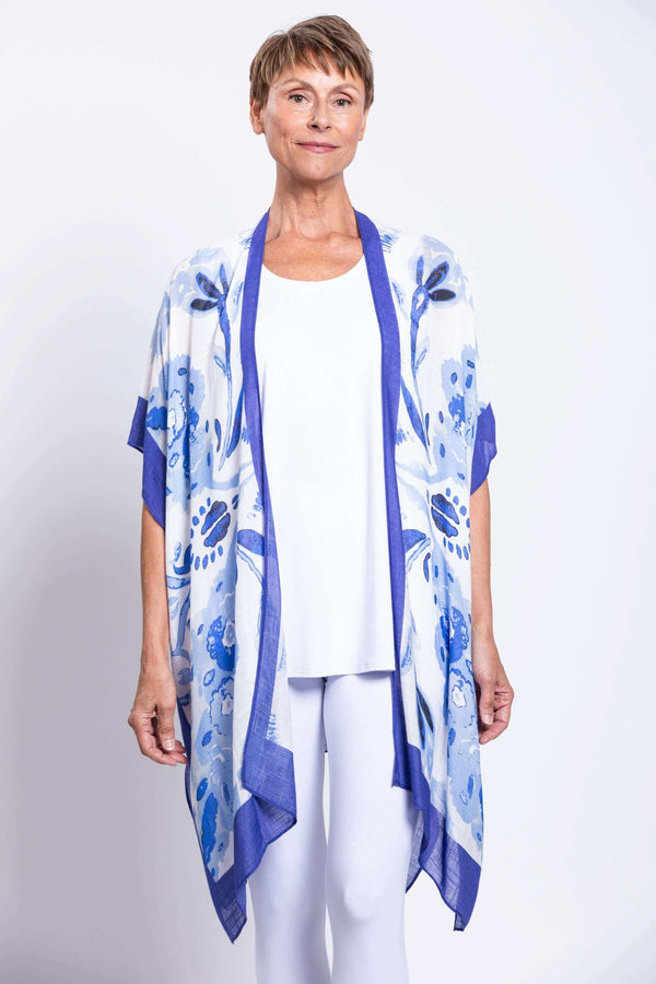 Front view of woman wearing blue floral Darcy kimono wrap over white outfit