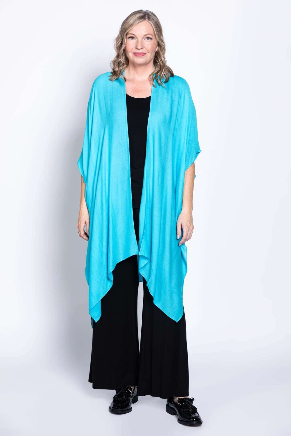 Front view of woman in turquoise Darcy kimono wrap and black clothing