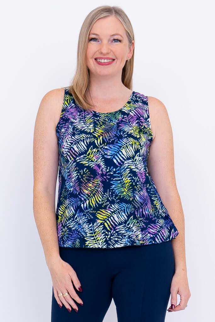 Front view of woman wearing a colorful sleeveless Dee Tank top with vibrant leaf print
