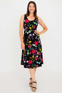 Woman wearing sleeveless black tank dress with vibrant floral print, front view