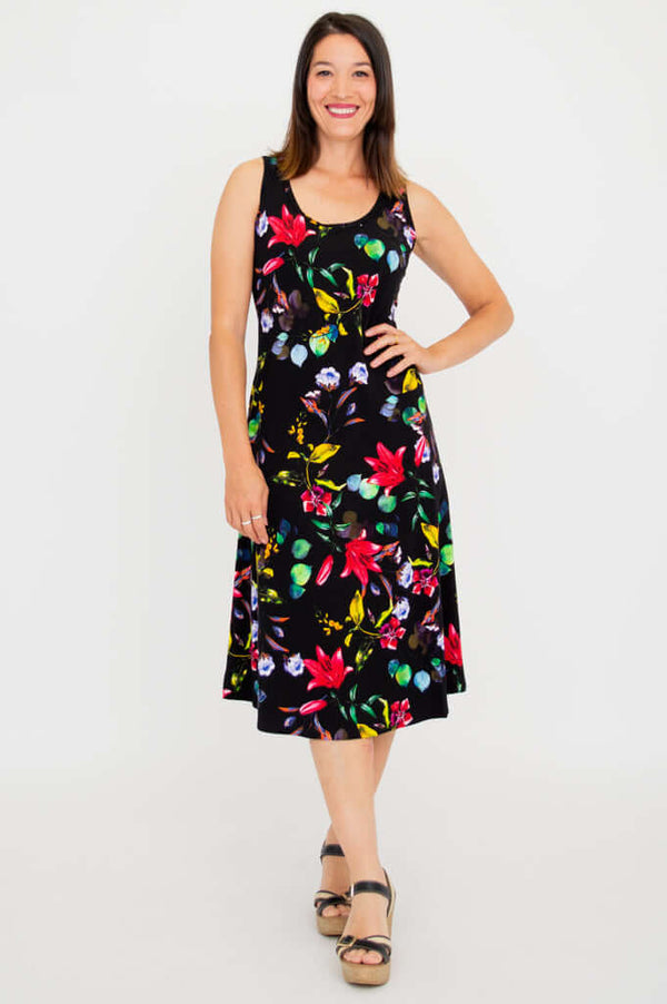 Woman wearing sleeveless black tank dress with vibrant floral print, front view