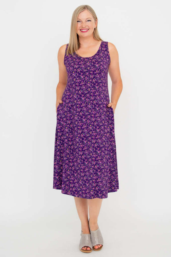 Front view of a woman wearing a purple floral sleeveless A-line tank dress with pockets