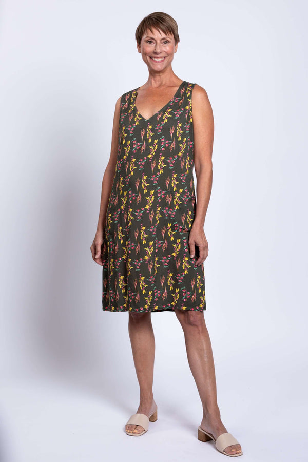 Woman wearing green floral sleeveless V-neck shift dress, front view