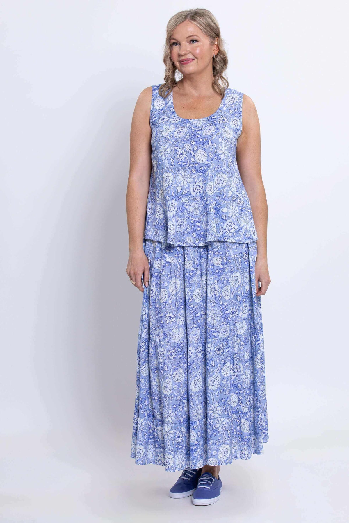 Woman in blue floral Ginny tank top and skirt, smiling, front view