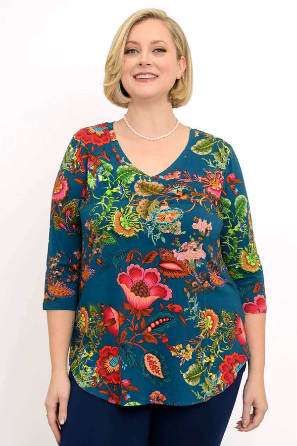 Woman wearing Jackie V Neck bamboo top with vibrant teal floral print, front view