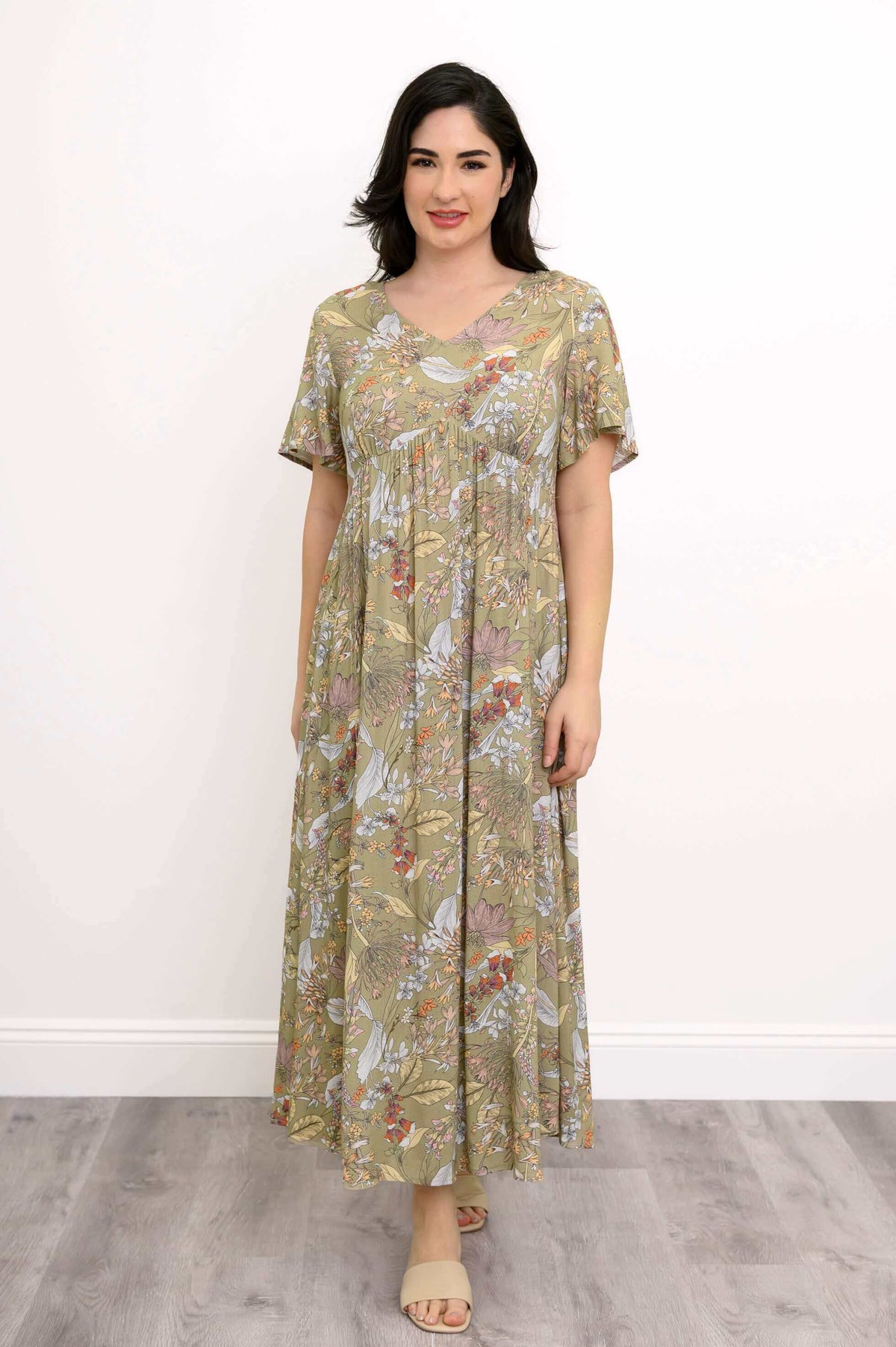 Front view of woman wearing green floral Jane empire waist maxi dress