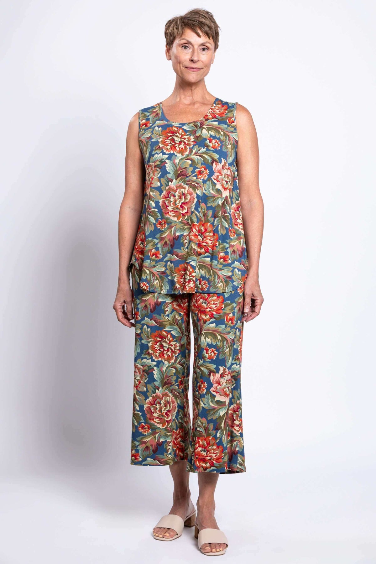 Woman standing in floral peony print tank top and matching pants, front view, arms by sides