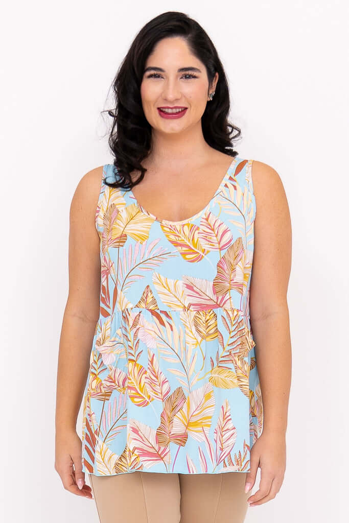 Front view of woman wearing light blue tank top with tropical leaf print