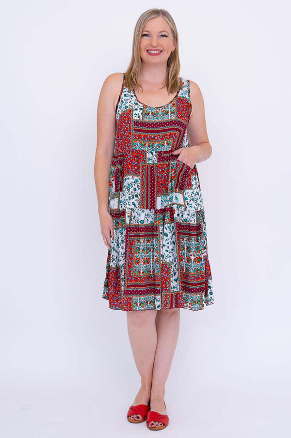 Front view of woman wearing sleeveless, tiered patchwork summer dress