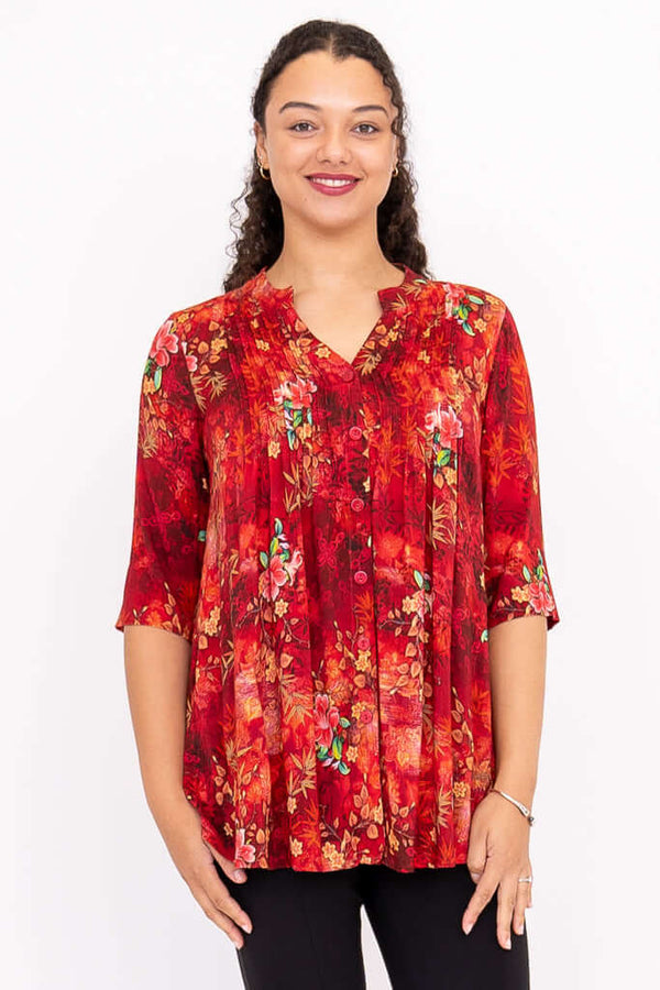 Front view of model wearing a vibrant red floral Margate blouse with mandarin collar