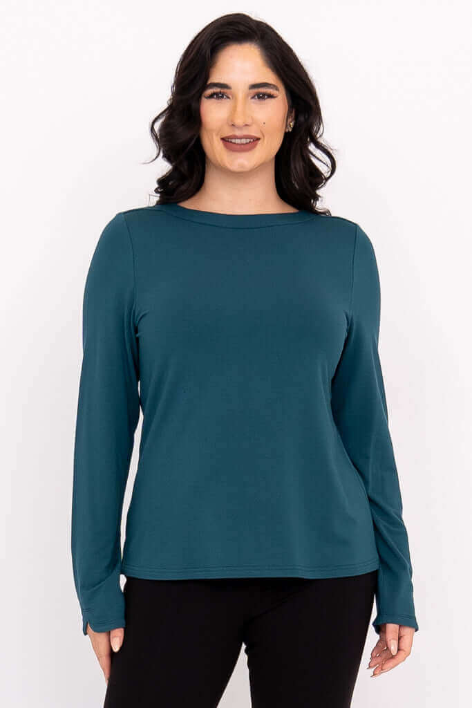 Front view of a woman wearing a teal boat neck long sleeve top and black pants