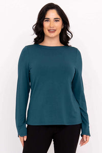 Front view of a woman wearing a teal boat neck long sleeve top and black pants